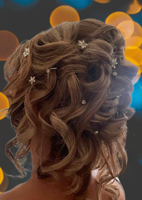 chignon-elegant-evenement-coiffure-attaches-boucles Chignon élégant vu de dos, avec boucles et attaches raffinées, orné de petites décorations florales, conçu pour une occasion spéciale comme un mariage ou une soirée chic.